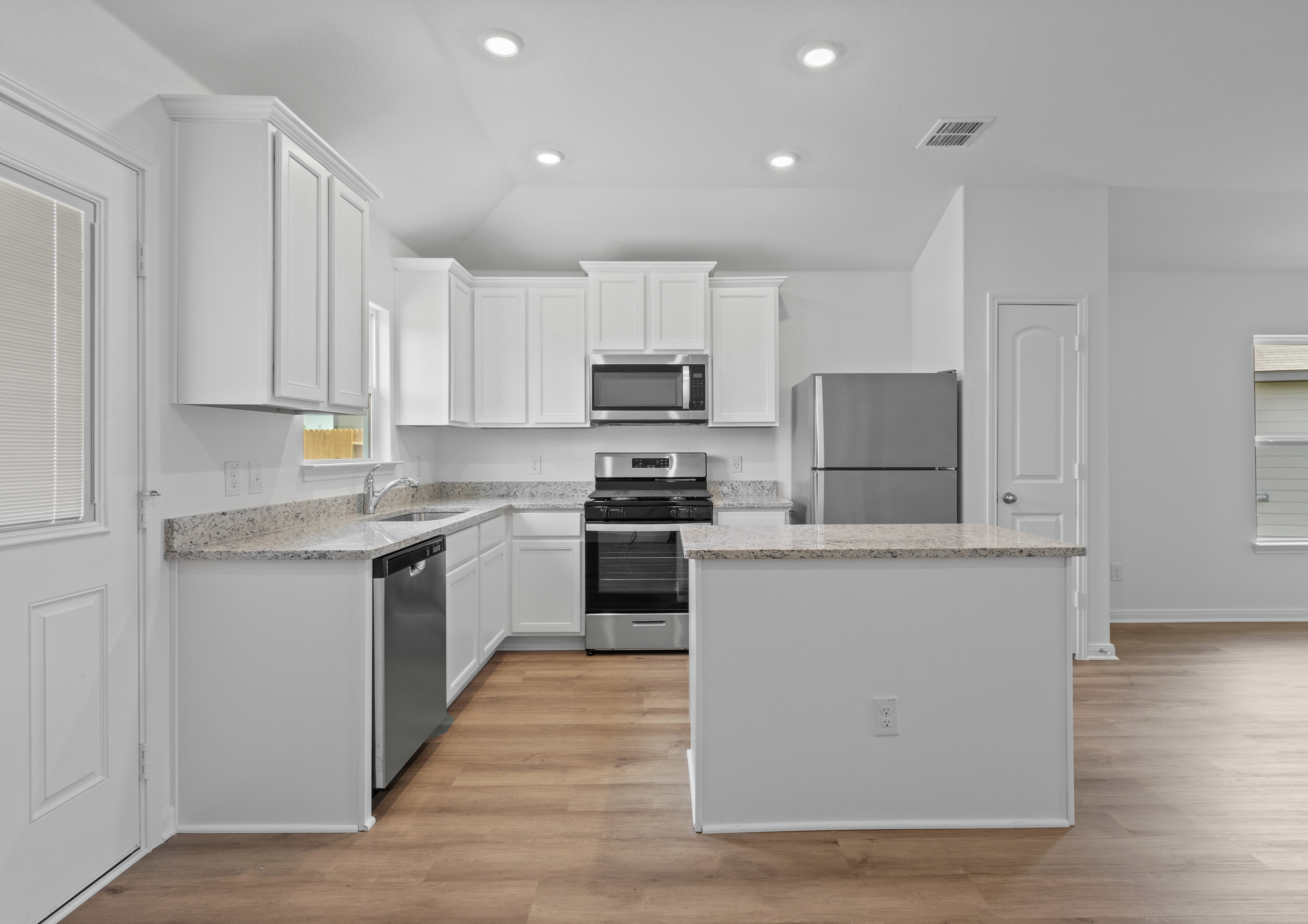 The kitchen features stainless steel appliances and granite countertops