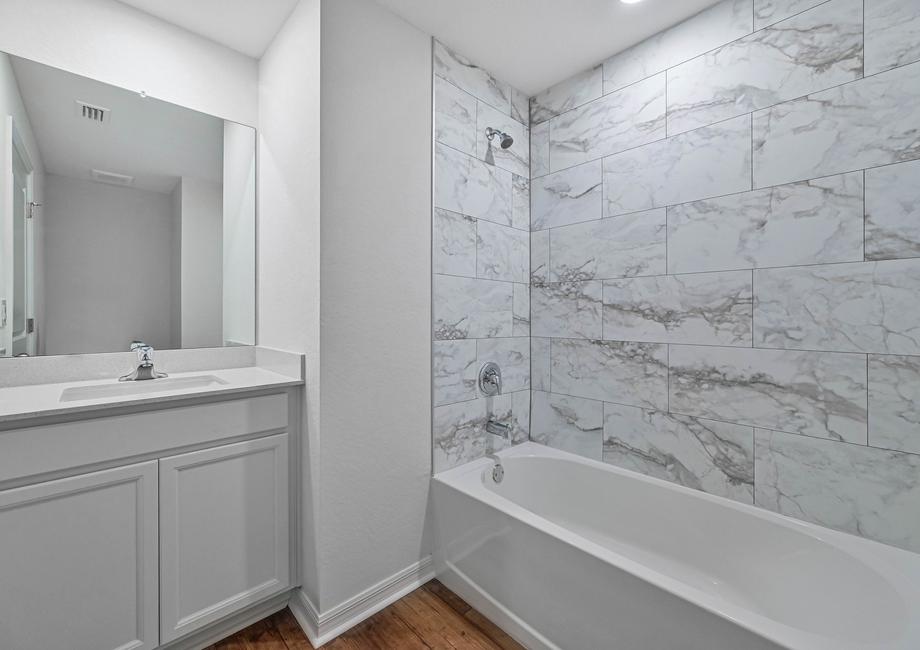 The second bathroom has a spacious vanity and a beautiful tiled bathroom