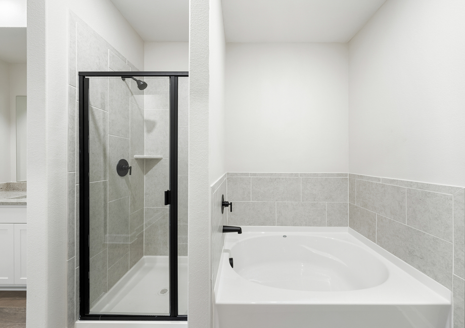 The master bathroom of the Driftwood has a glass, walk-in shower and large garden tub.