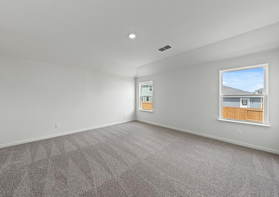 The spacious master bedroom has a large window that lets in natural light and backyard views.