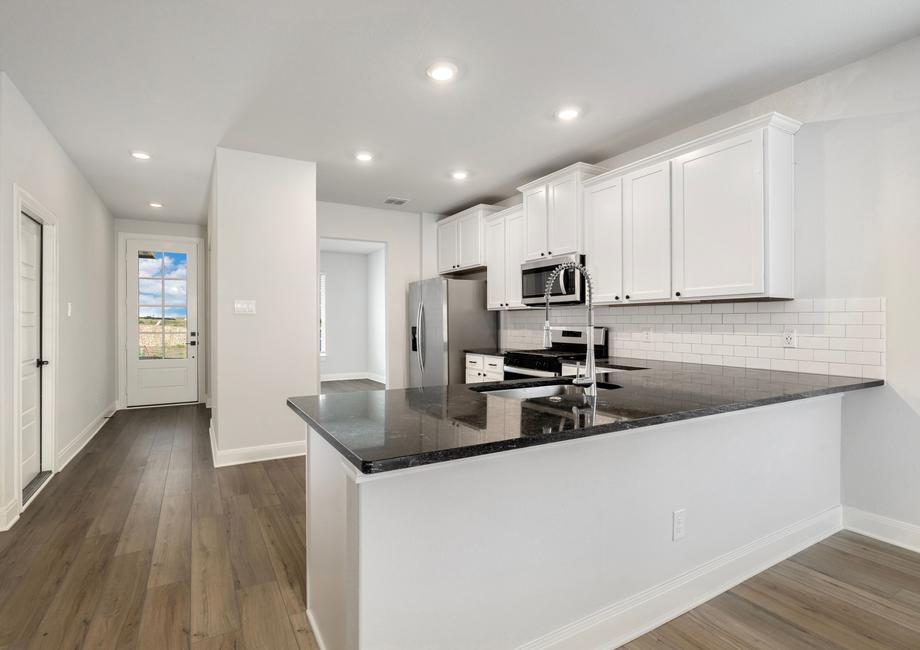 Upgraded kitchen with sprawling countertops and stainless steel appliances.