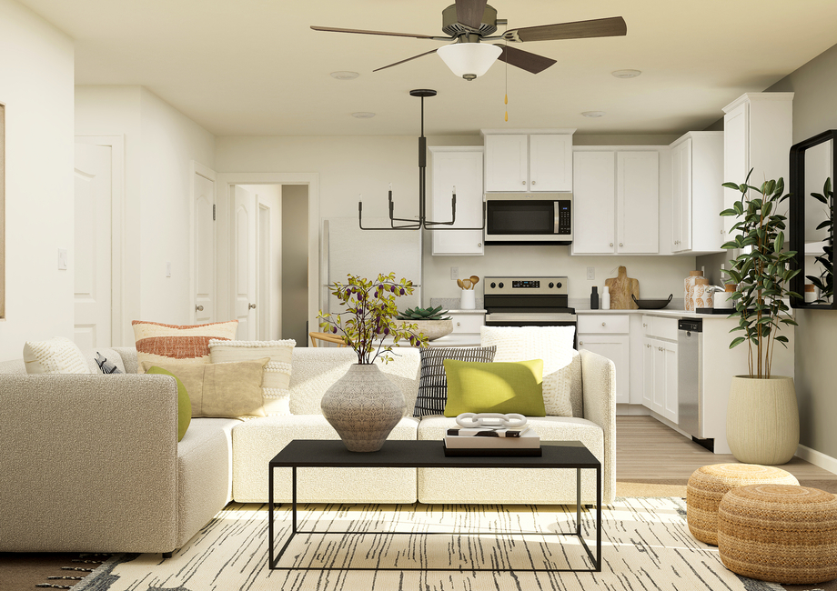 Rendering of a
  living room showing a large white sectional with a black coffee table. The
  kitchen can be seen behind the couch.