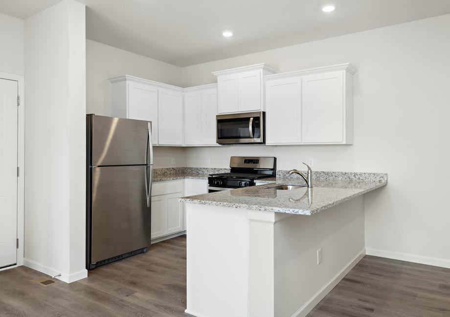 The kitchen has stainless steel appliances and plank flooring. 