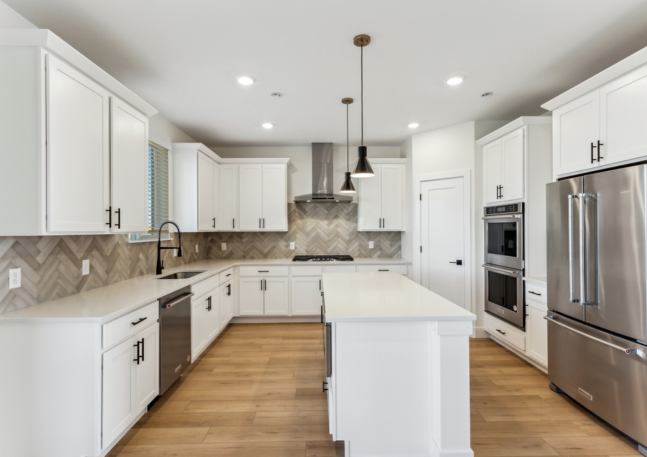 The kitchen has white wood cabinetry with black hardware.