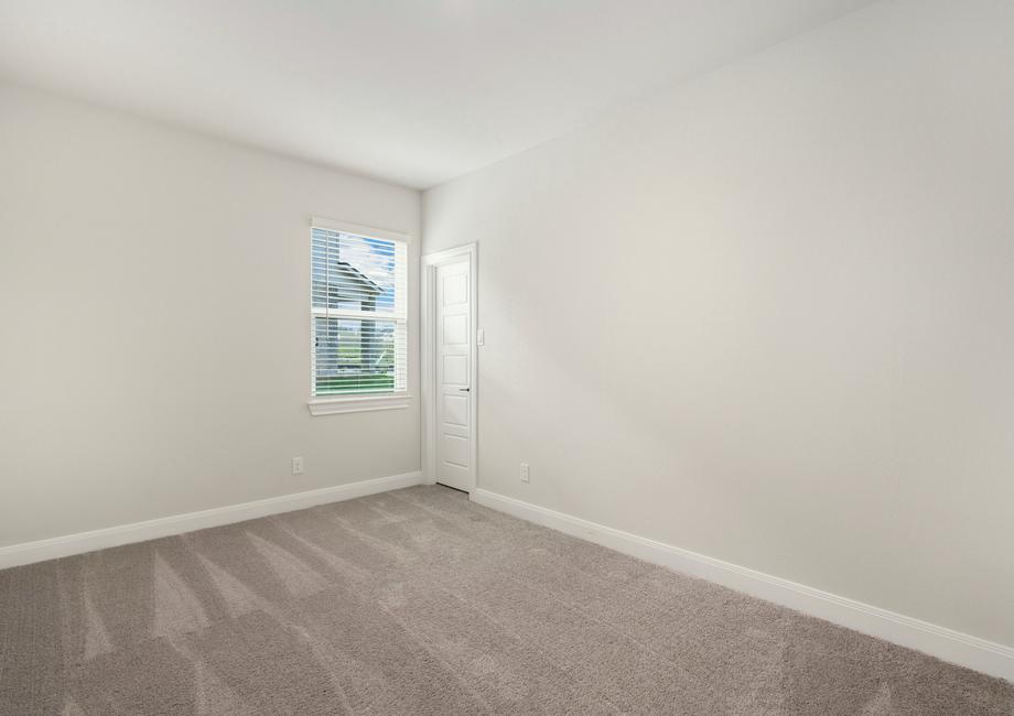 Secondary bedroom with tan carpet and a single window.