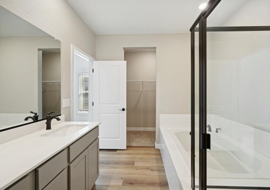 The master bathroom has a large glass, walk-in shower and a garden tub.