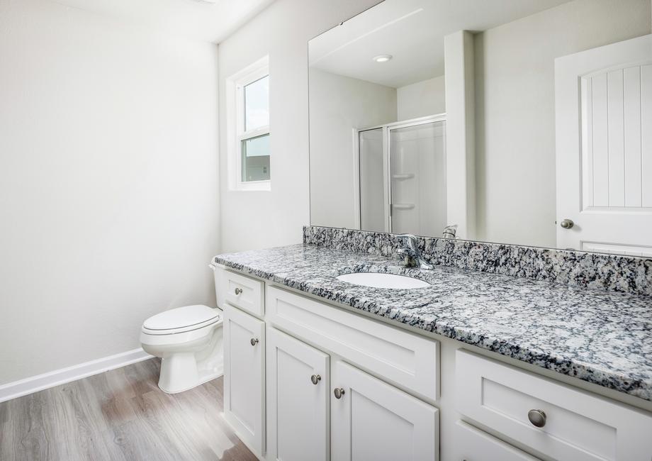 Master bathroom with a large vanity and granite countertops.