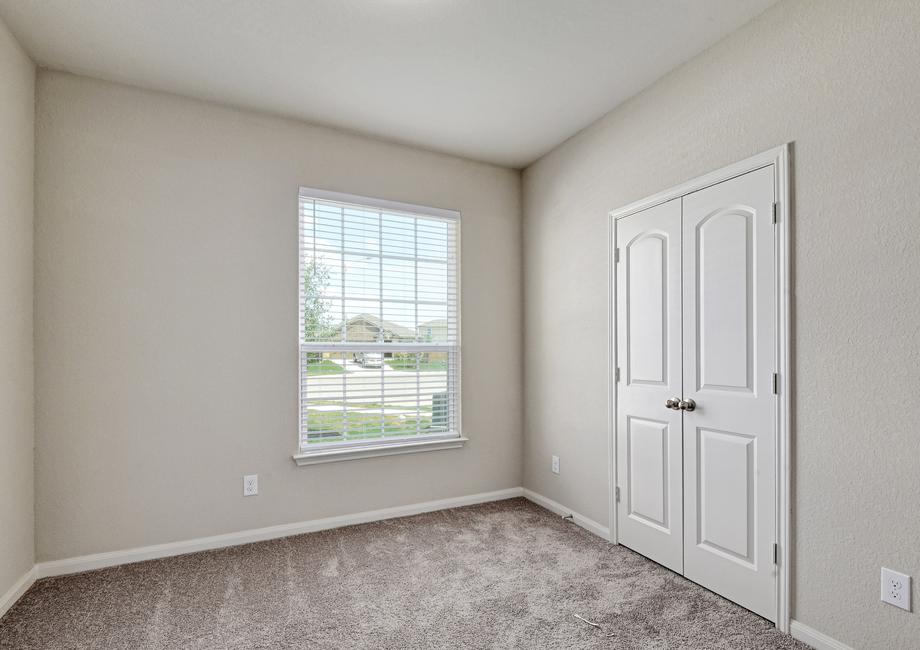 Secondary bedroom with a window and a closet with double doors.