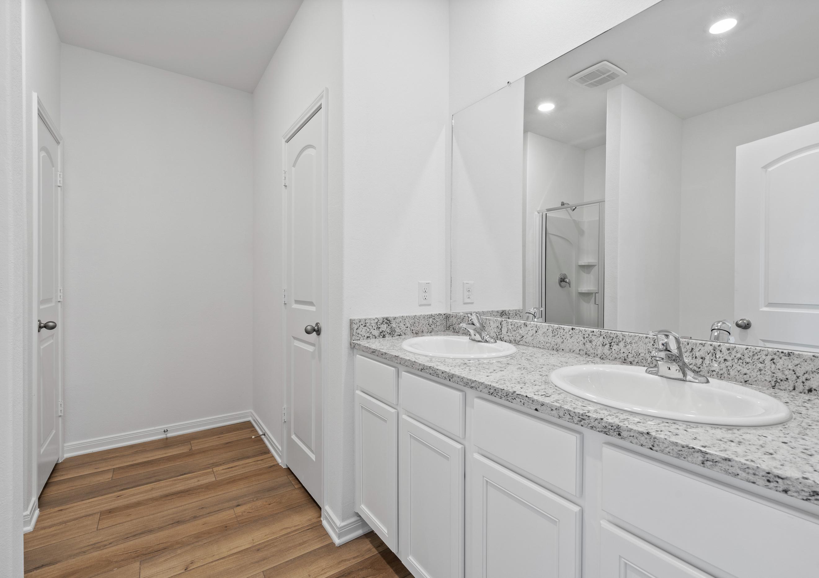 The master bathroom has a long vanity with two sinks.