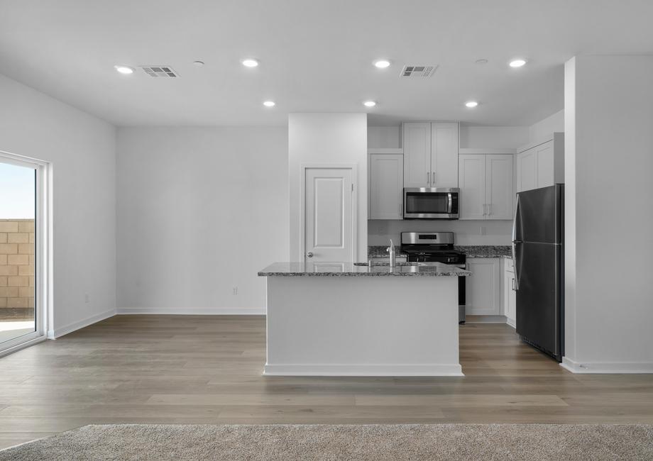 The kitchen is chef ready and has stainless steel appliances and plank flooring.