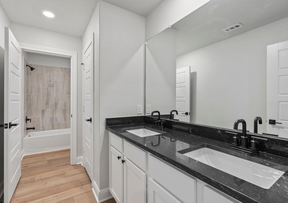 Secondary bathroom with two sinks and a private restroom.