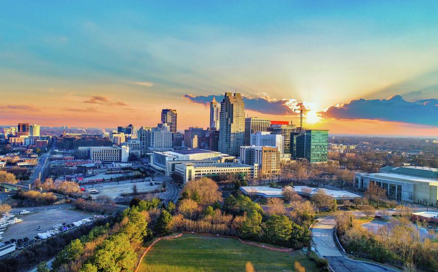 Raleigh, North Carolina downtown cityscape with large office buildings, parks, and other buildings at sunrise