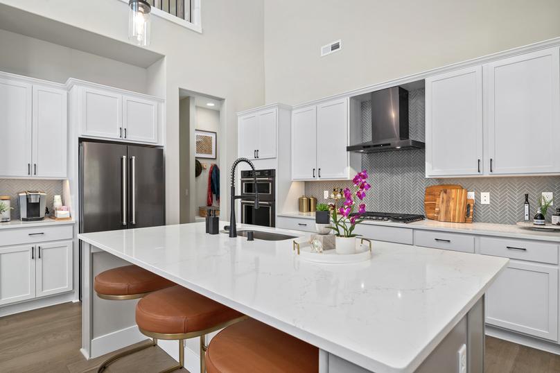 The kitchen highlights quartz countertops and black stainless steel appliances.