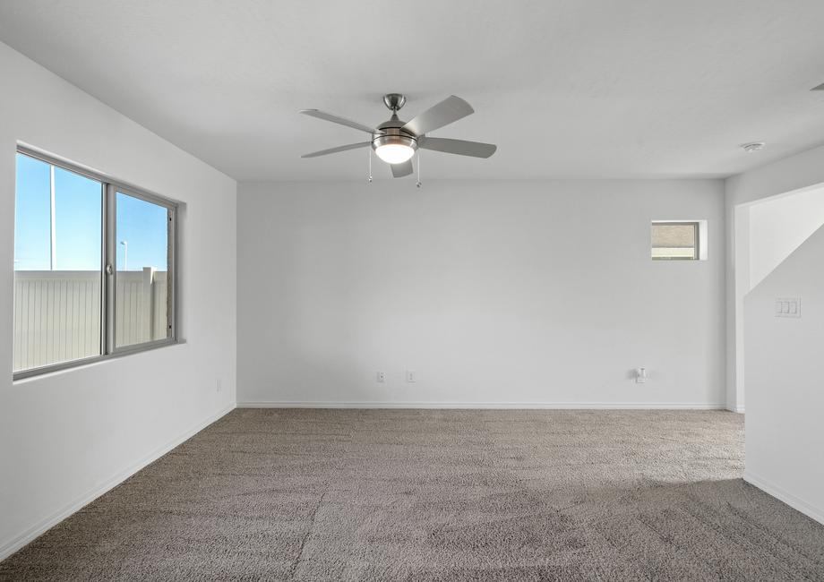 Spacious family room with carpet and a ceiling fan