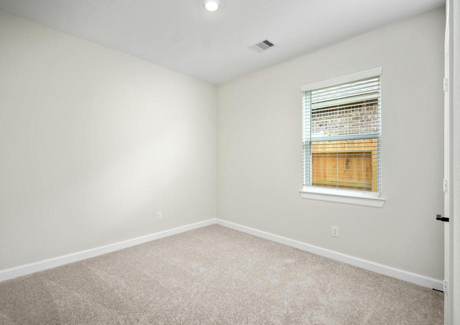 A secondary bedroom with lush carpet