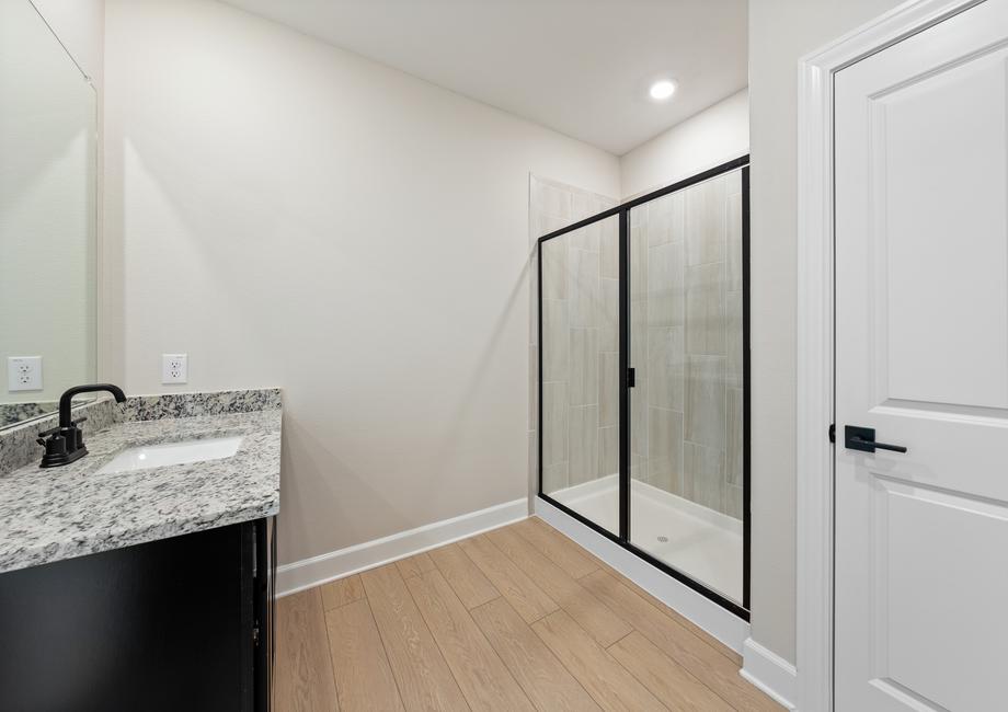 The master bathroom has a large vanity and beautiful walk-in, glass shower.