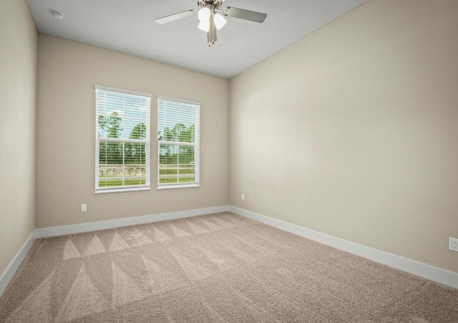 Secondary bedroom with carpet.