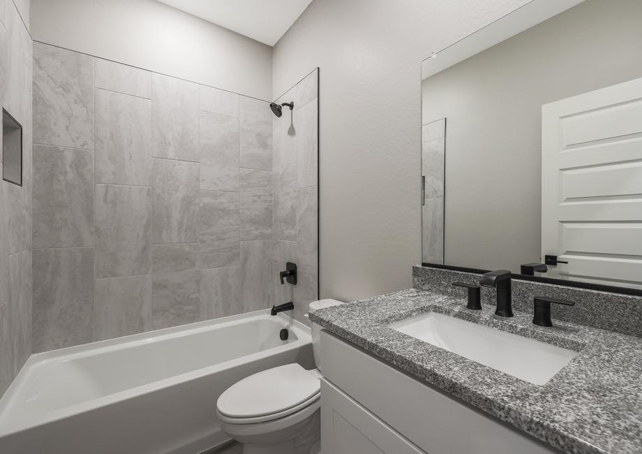 Secondary bathroom with granite countertops and a dual shower and tub.