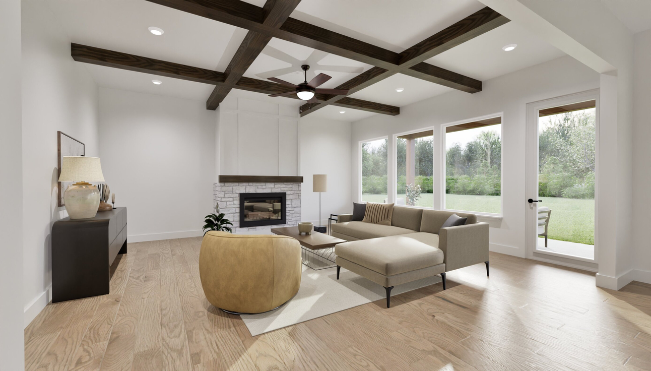 A modern living room with wooden ceiling beams, a white brick fireplace, L-shaped sofa, round beige ottoman, large windows, and light wood floor.