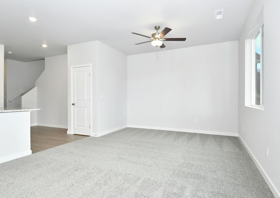 The family room is spacious and has a ceilng fan.