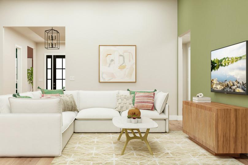 Rendering of the living room showing a
  large white couch and coffee table facing a media cabinet with tv atop a
  cream sofa and a view of the entryway in the background.