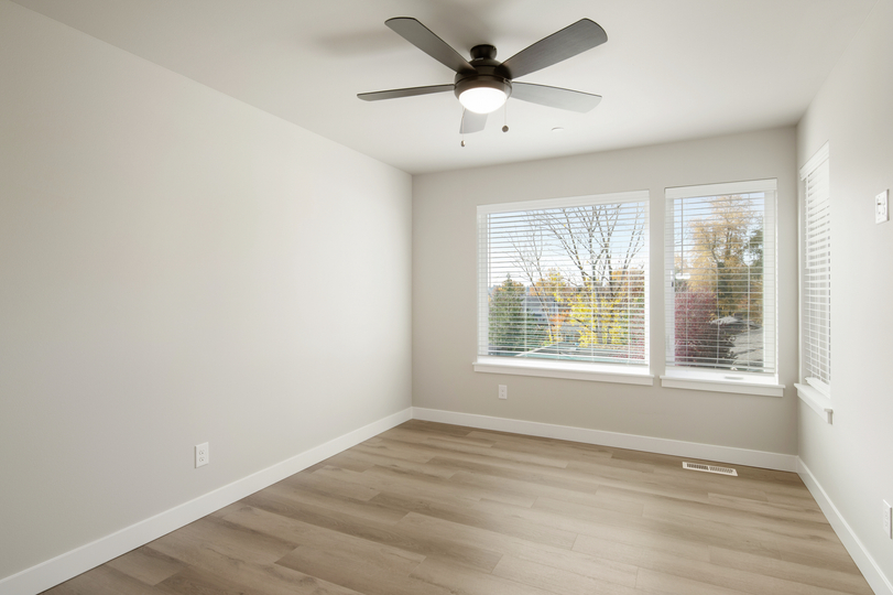 Master bedroom has gorgeous floors a cailing fan and large windows.