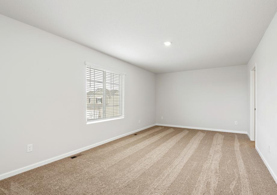 The master bedroom has a large window and carpet.