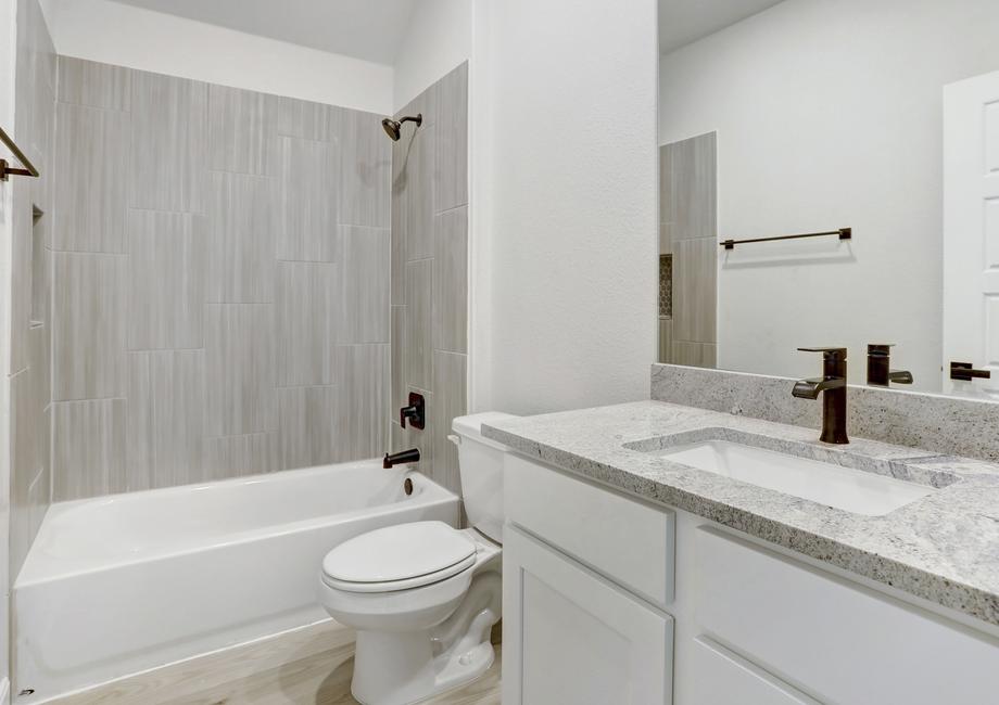 Secondary bathroom with a dual shower and tub.