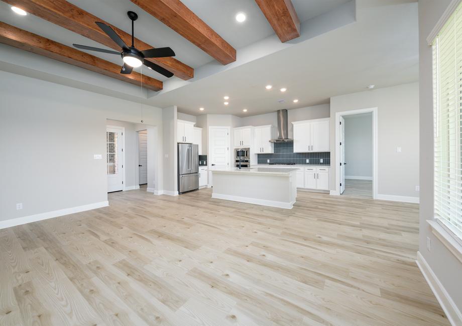 The gorgeous living room has a soaring ceiling with beams.