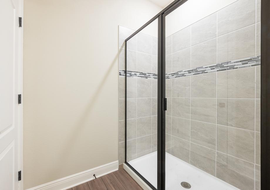 A walk-in shower with tile detail in the master bathroom.