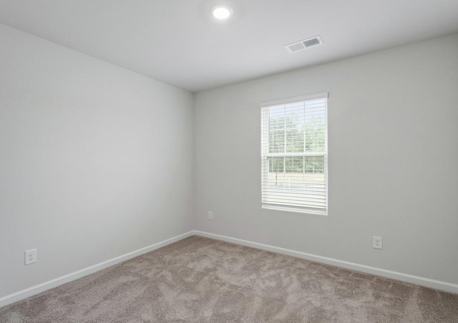 Secondary bedroom with a small window and carpet.
