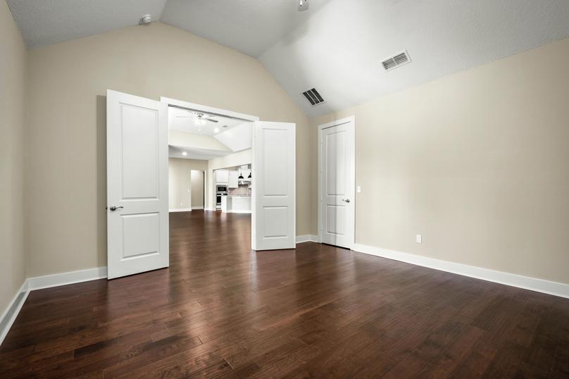 Media room with wood floors and double doors.