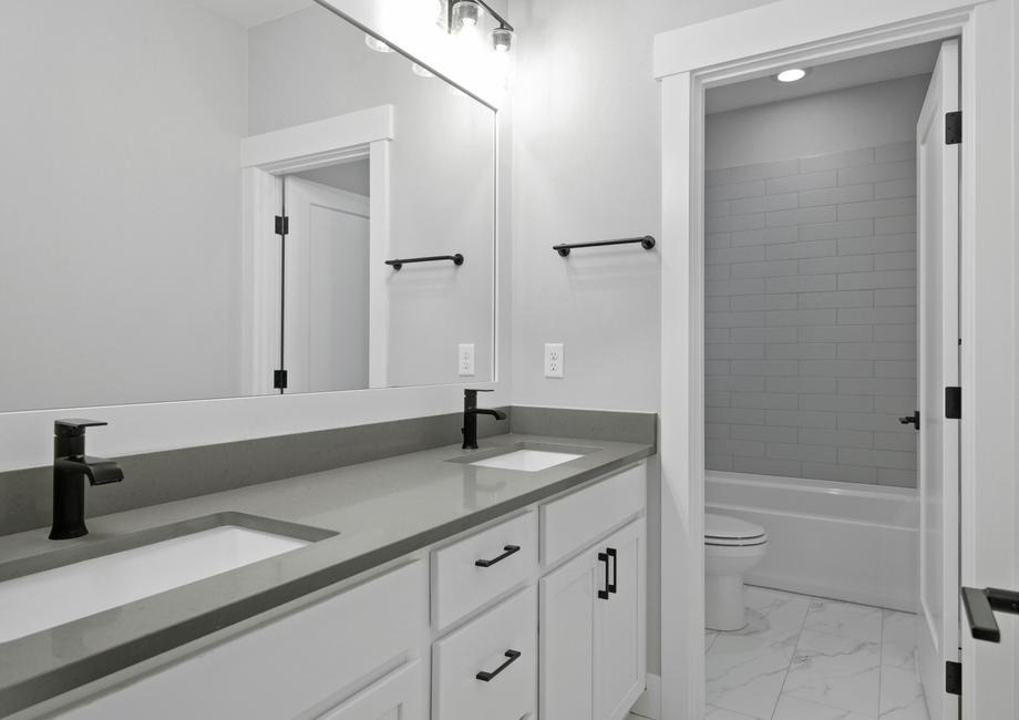 The secondary bathroom showcases a large dual sink vanity.