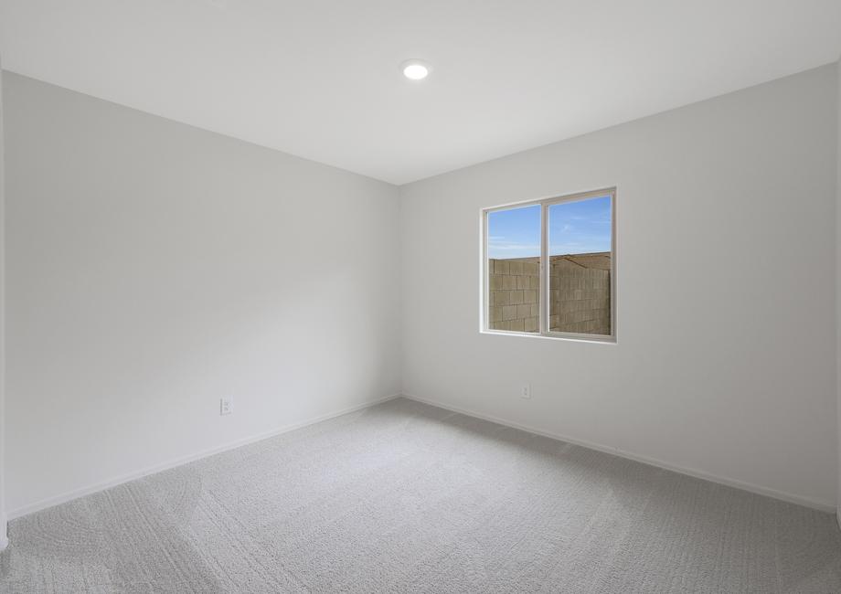 Additional bedroom with windows, recessed lighting, and tan carpet.