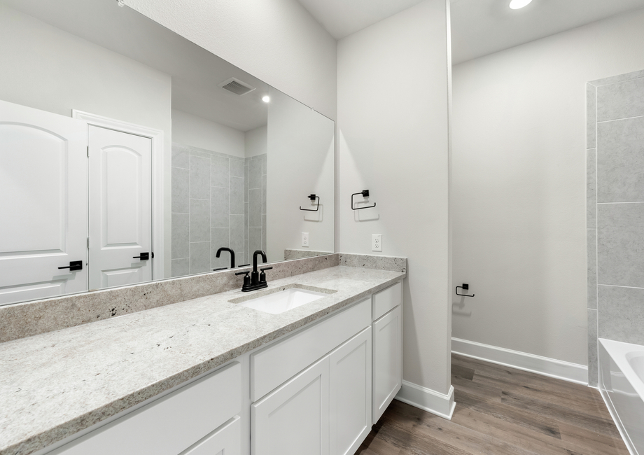 The secondary bathroom has a large vanity with plenty of counterspace and a shower-tub combo.