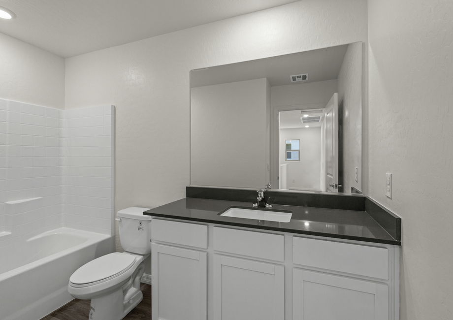 The secondary bathroom of the Cypress plan has a large vanity space and shower-tub combo.