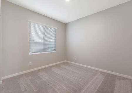 Secondary bedroom with tan carpet and recessed lighting.