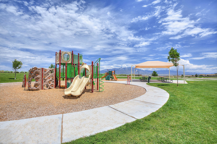 The Entrada at High Range community park with covered bench areas and grass fields all around it.