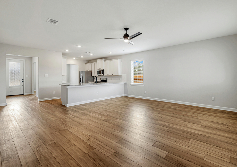 The foyers leads to an adjoining living room and kitchen with luxury vinyl flooring