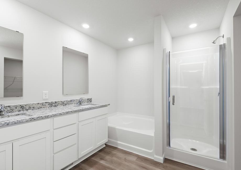 The master bathroom has a step in shower and soaking tub, as well as a dual sink vanity.