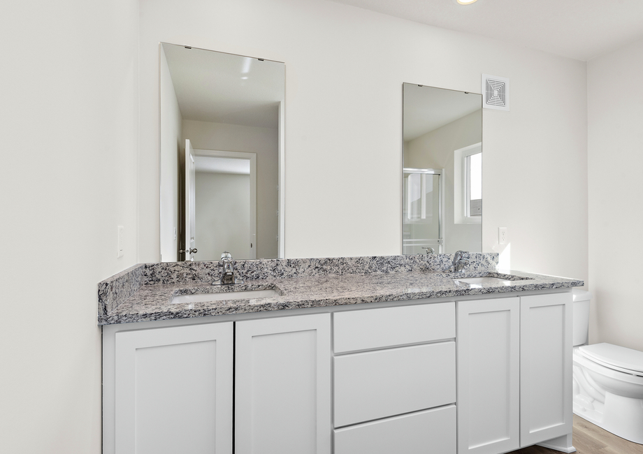 The master bathroom has a dual sink vanity and a step in shower.