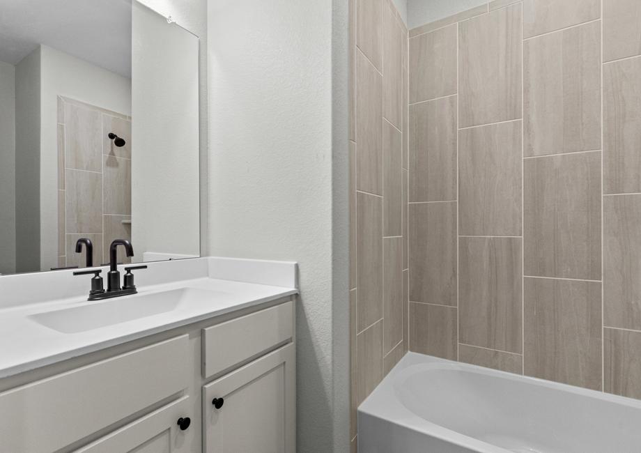 The guest bathroom comes equipped with both a vanity and shower bath.