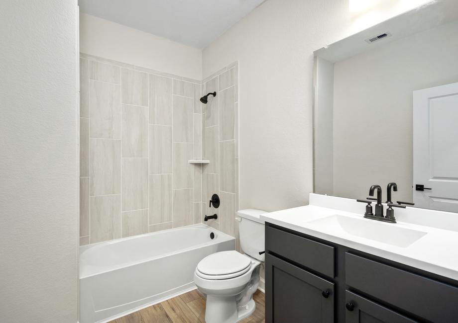 The secondary bathroom with modern finished including mate fixtures and tile detail