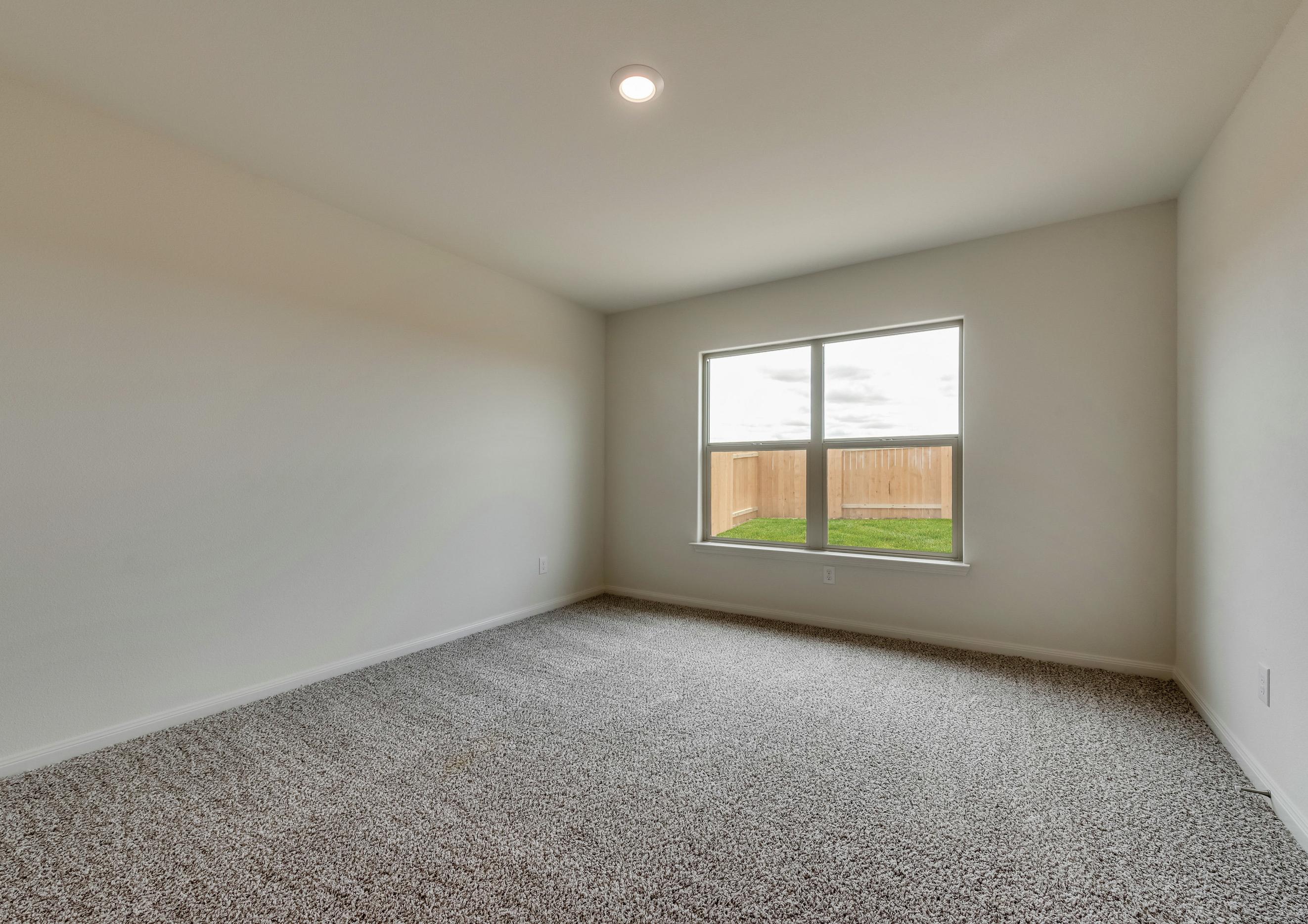 The master suite has great natural light, brown carpet and white walls.