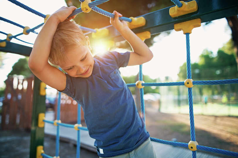 Little boy playing on playground.