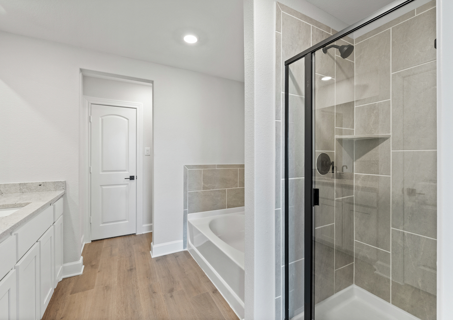 The master bathroom has a large glass, walk-in shower and garden tub.