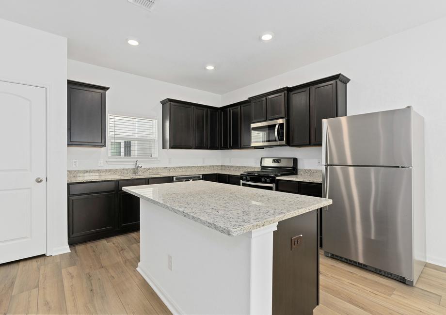 Chef-ready kitchen with a large island, stainless appliances, and granite countertops.