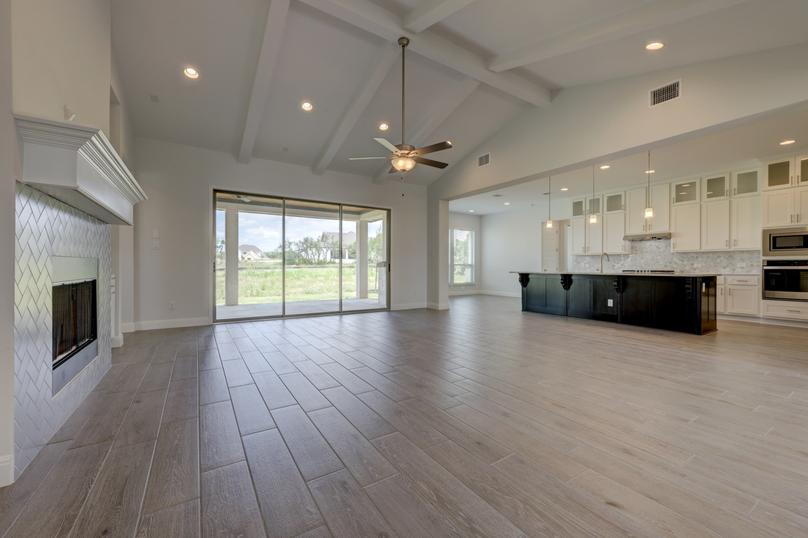 Open layout with the spacious family room peering out onto the back yard through large glass windows.