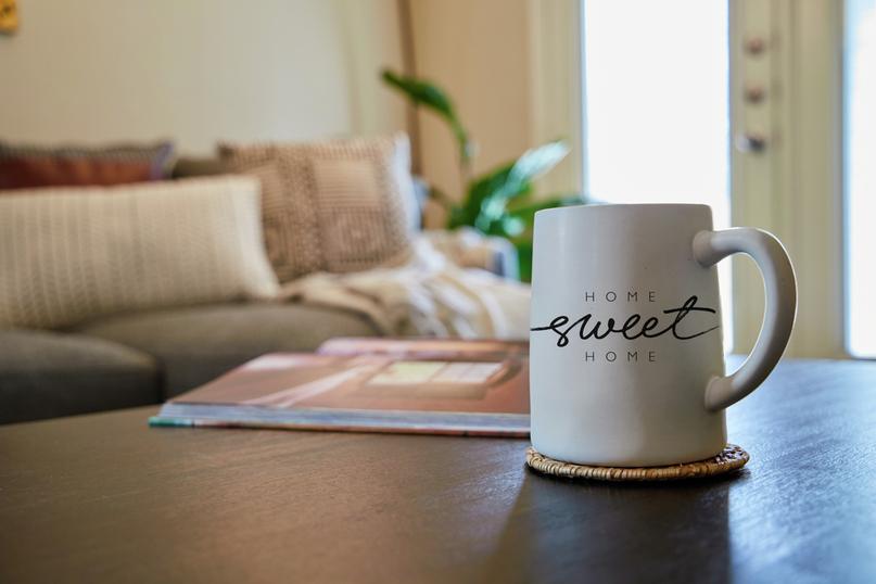 Mug with "Home Sweet Home" text on it on a table in a living room