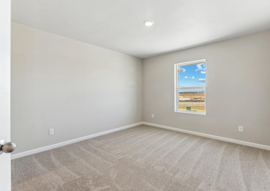 The secondary bedroom has carpet and a nice window.